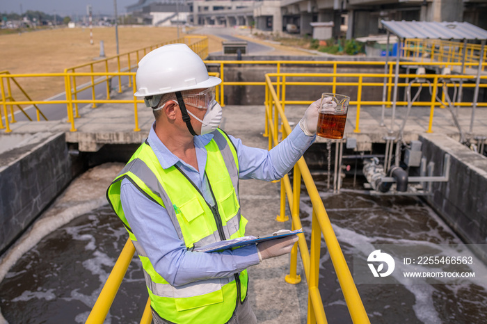 Worker under checking the waste water treatment pond industry large to control water support industry.