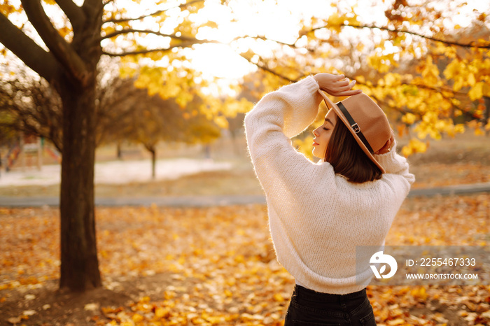 Stylish woman enjoying autumn weather in the park. Fashion, style concept.