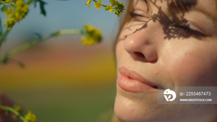 Gentle lady portrait with blooming colza. Woman face smiling to nature outdoors.