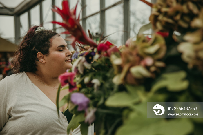 plus size woman smells flowers