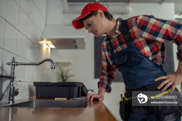 Plumber inspecting the water tap of in a customer apartment