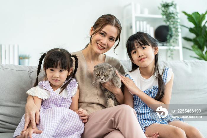 Portrait of Asian family spend leisure time with domestic cat together