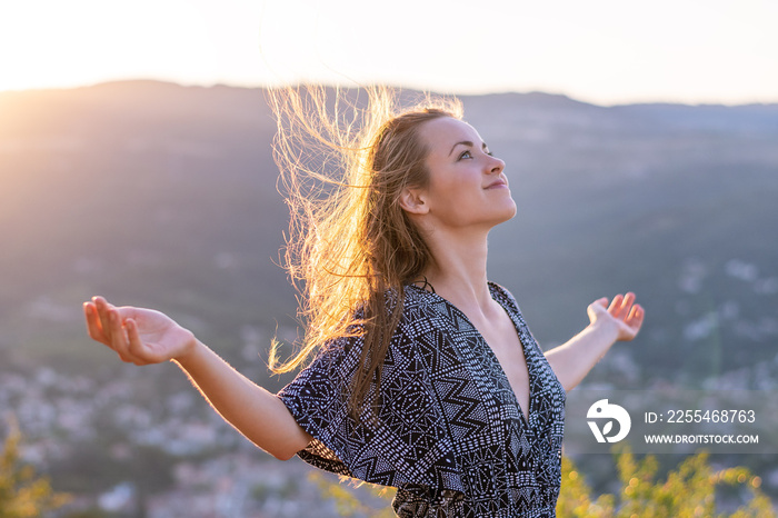 Christian worship and praise. A young woman with her hands raised in worship and praise to god.