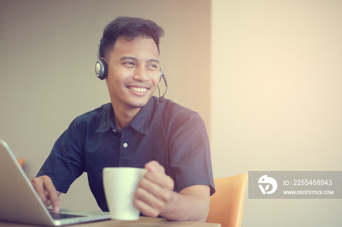 close up asian man working in office room with hand holding coffee cup ,relax after work hardvintage color effect