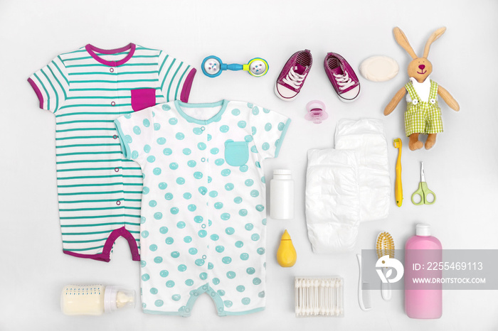 Baby care accessories and clothing on light background, top view