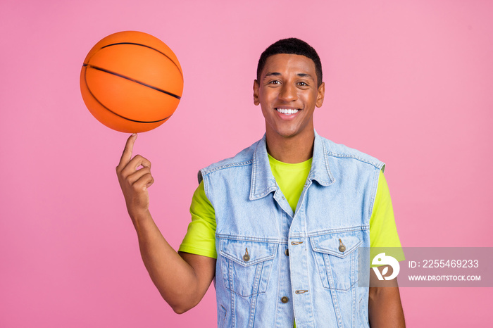 Photo of cool young brunet guy play basketball wear t-shirt vest jeans isolated over pink color background