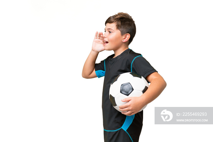 Little caucasian football player kid over isolated chroma key background shouting with mouth wide open to the side