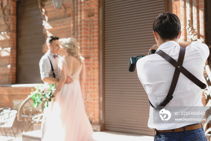 wedding photographer takes pictures of bride and groom