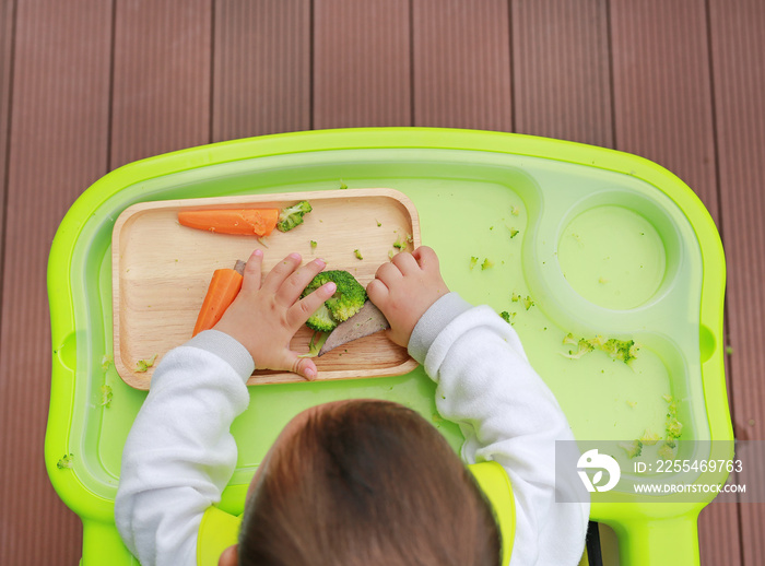 Top view of infant baby eating by Baby Led Weaning (BLW). Finger foods concept.