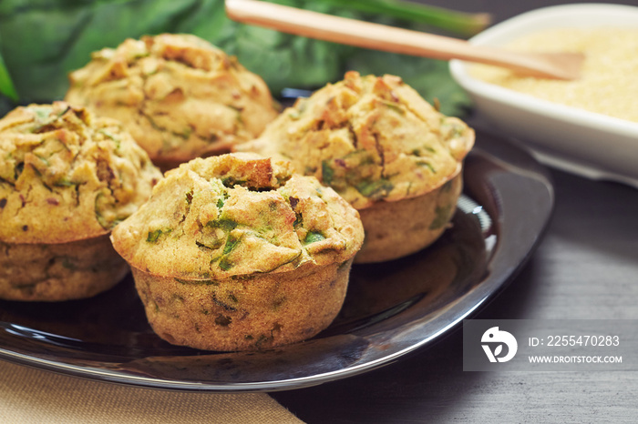 Vegan muffins with spinach and corn flour served on black plate