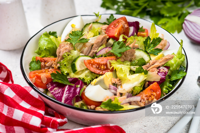 Tuna salad with green leaves, eggs and vegetables.