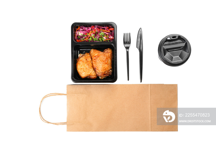 Lunch box with food, cutlery, cup and paper bag on white background