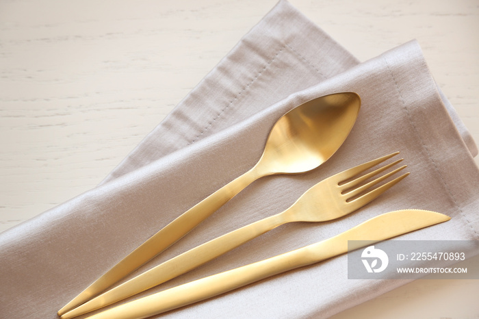 Fork, spoon and knife on linen napkin
