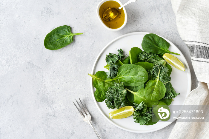 green salad of organic spinach and kale leaves with lemon juice and olive oil. diet menu concept, healthy food, save space, selective focus, light background,