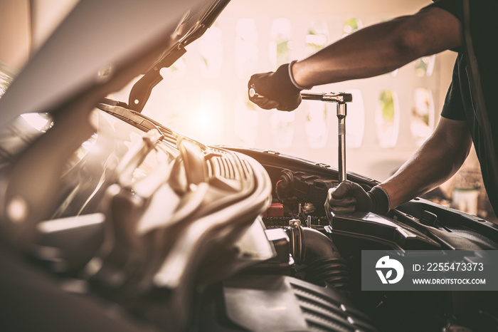 Close-up hand auto mechanic using the wrench to repairing car engine problem. Concepts of check and inspection car care maintenance and servicing.