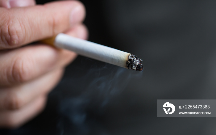 close up of male hand with smoking cigarette