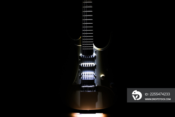 White electric guitar. Neck and fingerboard of musical instrument. Creative style with light shadows.