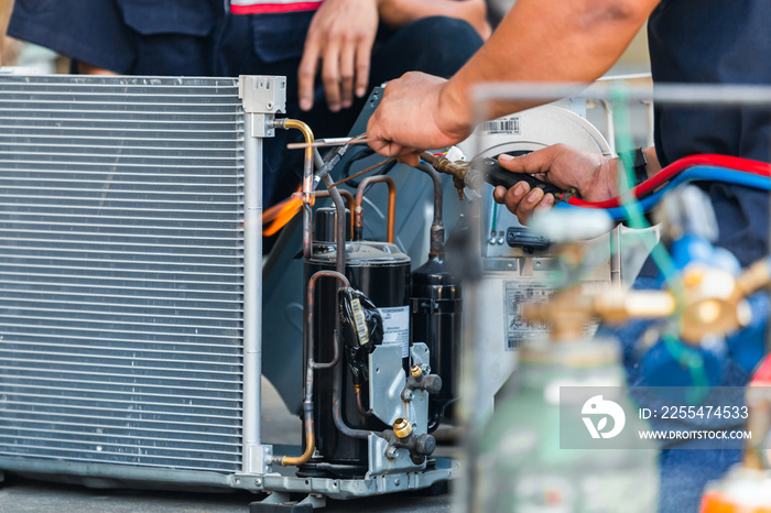 Close up of Air Conditioning Repair team use fuel gases and oxygen to weld or cut metals, Oxy-fuel welding and oxy-fuel cutting processes, repairman on the floor fixing air conditioning system