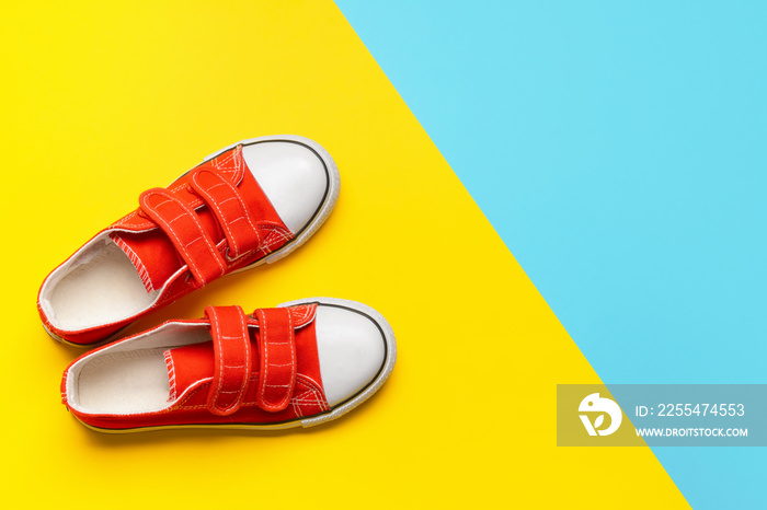 Child’s shoes on color background