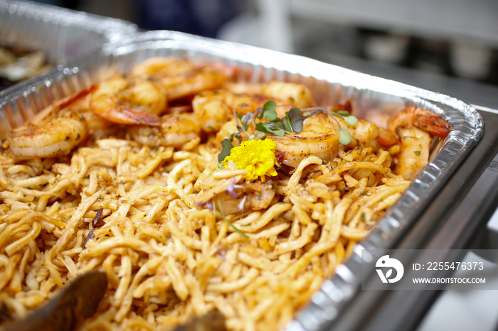 A closeup view of a chafer dish filled with savory entrees, seen at a local catered event.