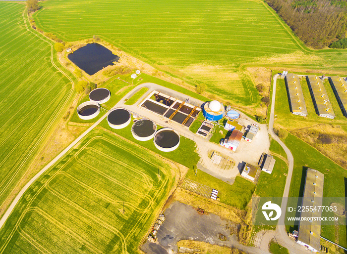 Aerial view to biogas plant from pig farm in green fields. Renewable energy from biomass. Modern agriculture in Czech Republic and European Union.