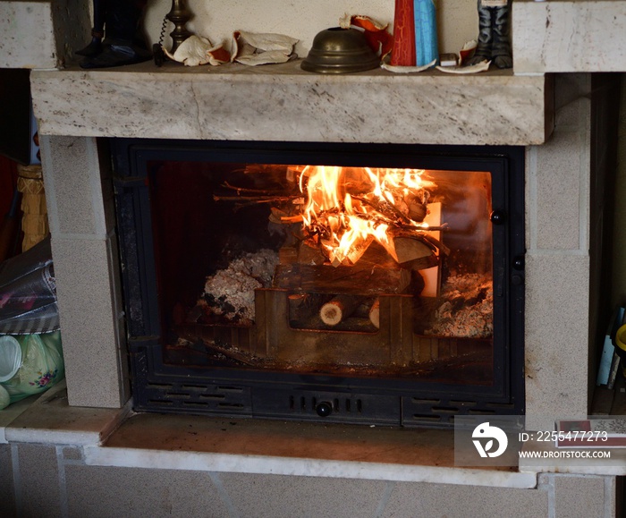 Flames of a burning fire in a fireplace insert in a cottage