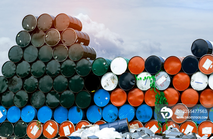 Old chemical barrels. Blue, orange, and black oil drum. Steel oil tank. Toxic waste warehouse. Hazard chemical barrel. Industrial waste in metal drum. Hazard waste storage in factory. Stack of barrel.