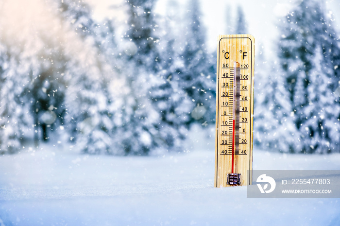 Thermometer in snow with backlight. Winter thermometers show minus temperature.