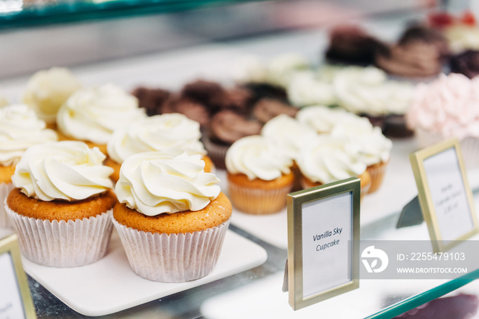 Shop window with vanilla cupcakes, bakery store