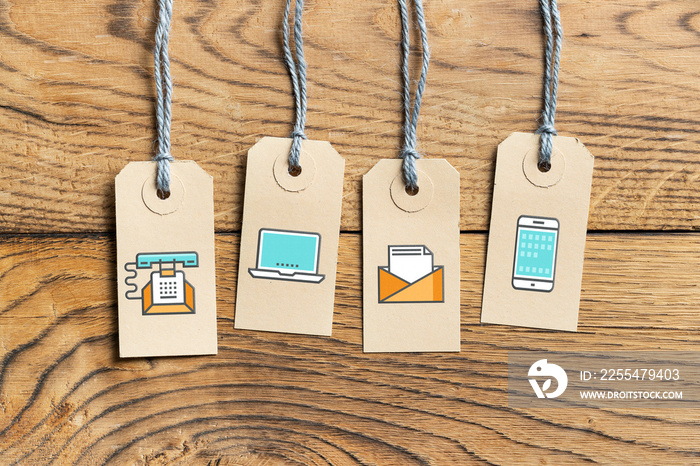 Hangtags on wooden background with contact option icons
