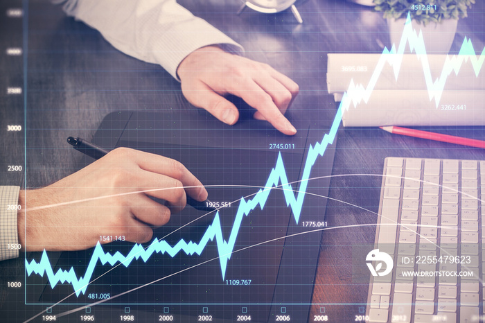 Double exposure of man’s hands holding and using a phone and financial graph drawing. Analysis concept.