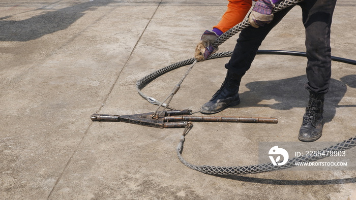 Part of electrician holding stainless steel slack grip for pulling cables in high quality electrical installation system work