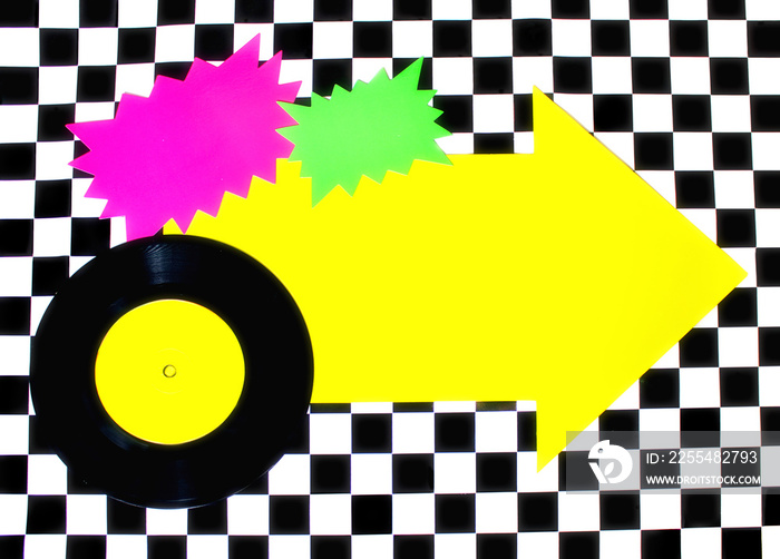 Photograph of 45rpm record with colorful shapes on Checkered floor