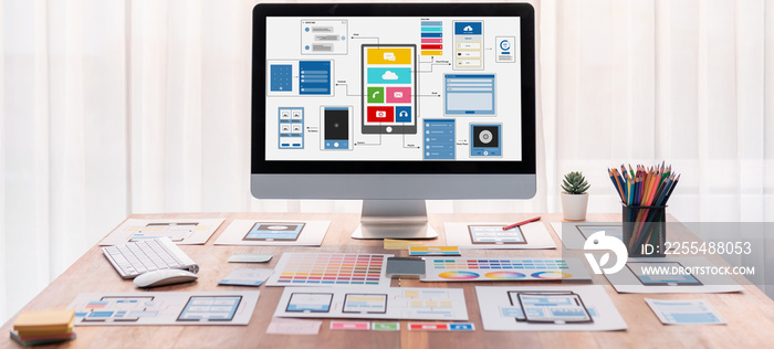 Digital and paper wireframe designs for web or mobile app UI UX display on laptop computer screen. Panoramic shot of developer workspace for brainstorming and design application framework. Scrutinize