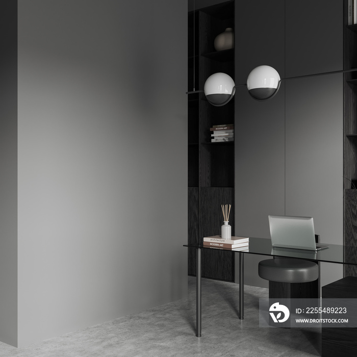 Grey workplace interior with laptop on table and decoration, mockup wall