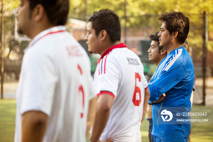 Side view of soccer players standing in field