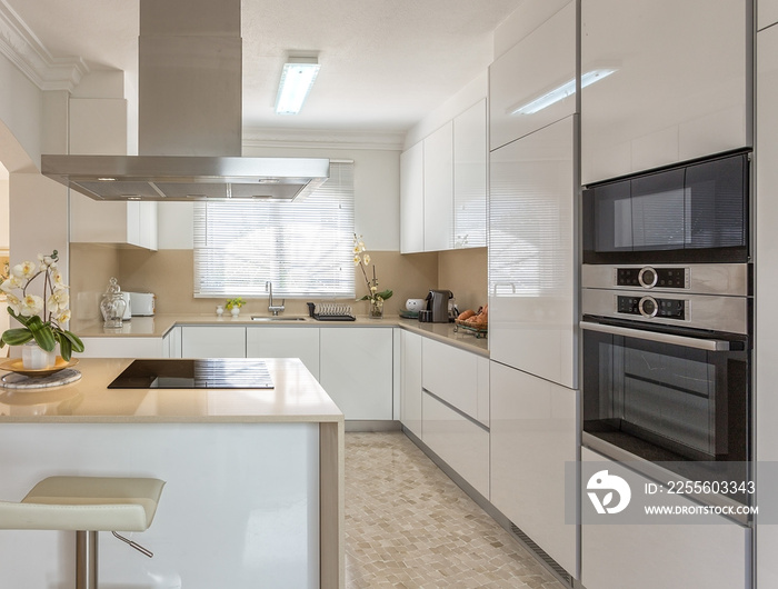 Modern kitchen with electric stove and appliances for use.