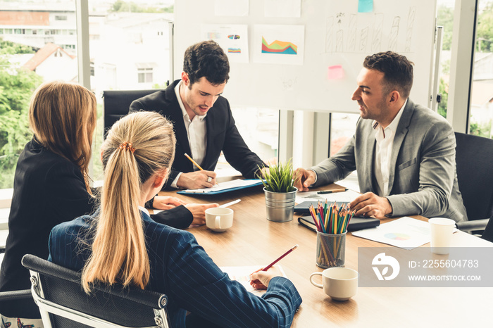 Businessman executive in group meeting discussion with other businessmen and businesswomen in modern