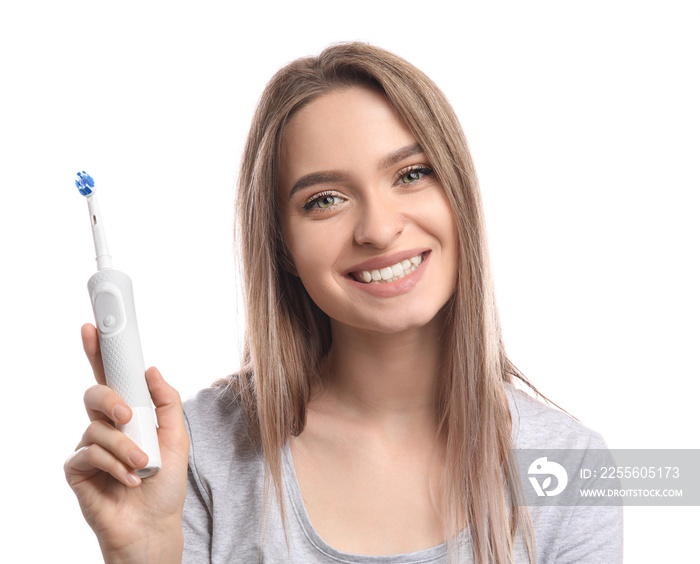 Young woman with electric tooth brush on white background