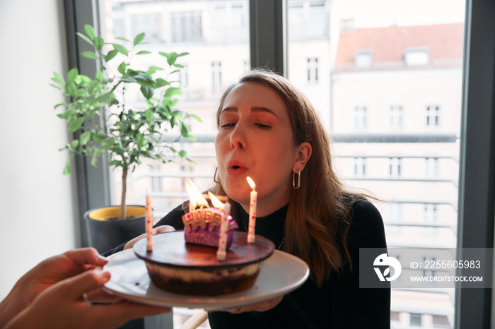 女人吹灭生日蛋糕上的蜡烛