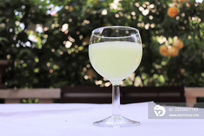 Verre de pastis mélangé avec de leau dans un verre rond transparent sur une nappe blanche - Départe