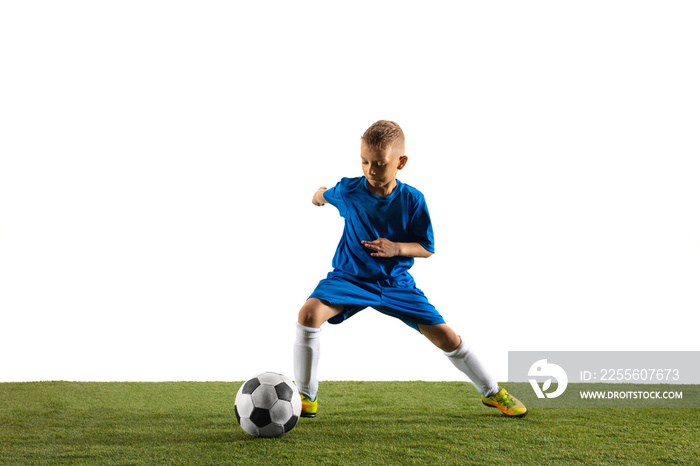 Young boy as a soccer or football player in sportwear making a feint or a kick with the ball for a g