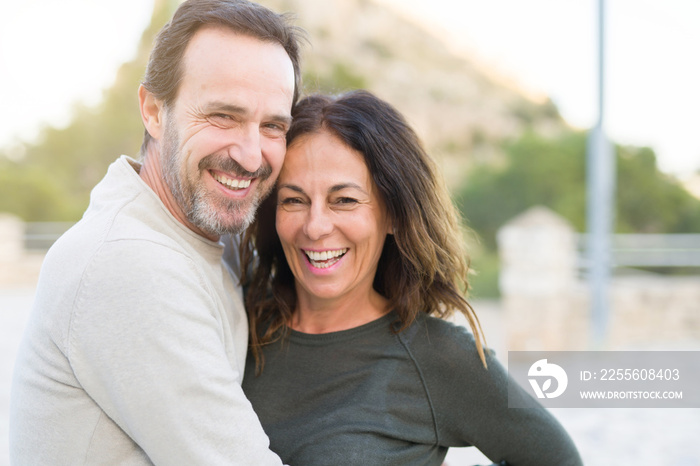 Romantic couple smiling and cuddling on a sunny day