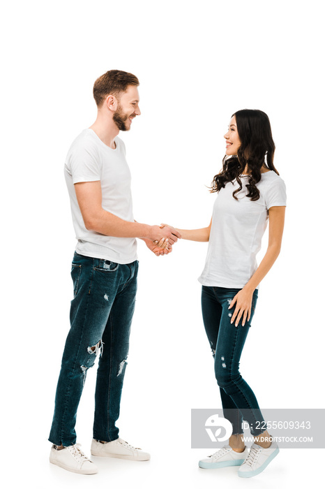 happy young couple shaking hands and smiling each other isolated on white