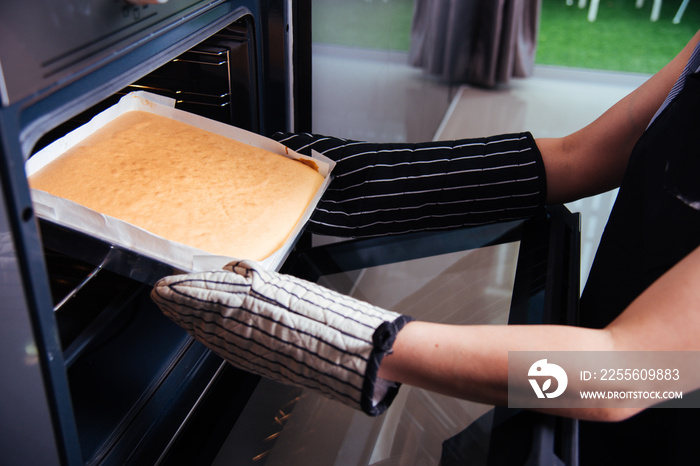 Hands of baker holding dough bread fresh on front oven