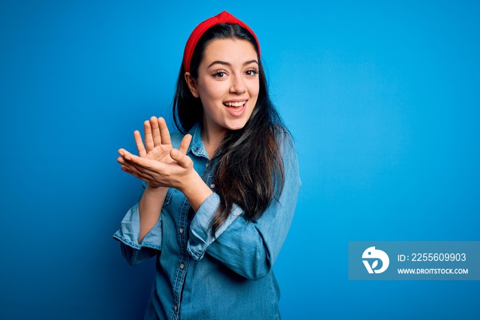 Young brunette woman wearing casual denim shirt over blue isolated background clapping and applaudin