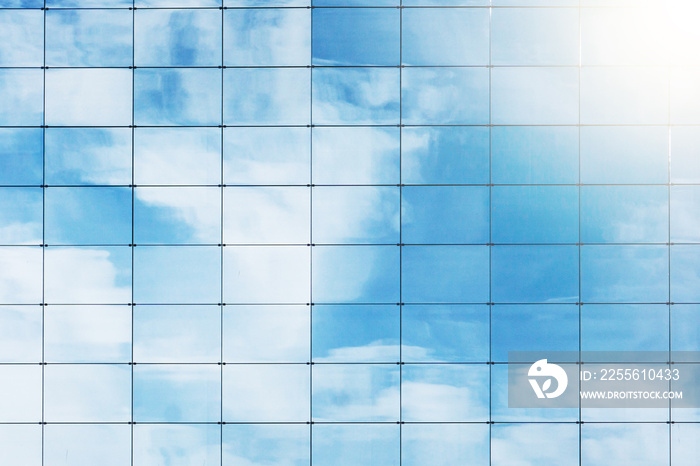 Office block texture. Glass skyscraper background. Glass window building. Blue, cloudy sky and sunli