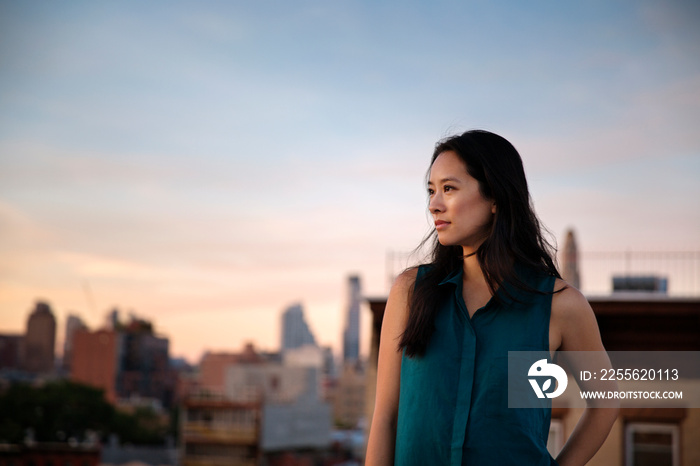 Woman looking at sunset from rooftop