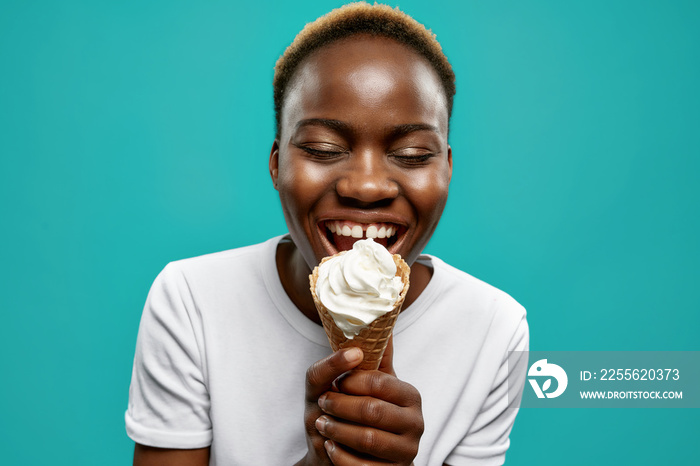 Happy african girl holding waffle horn with white ice cream.