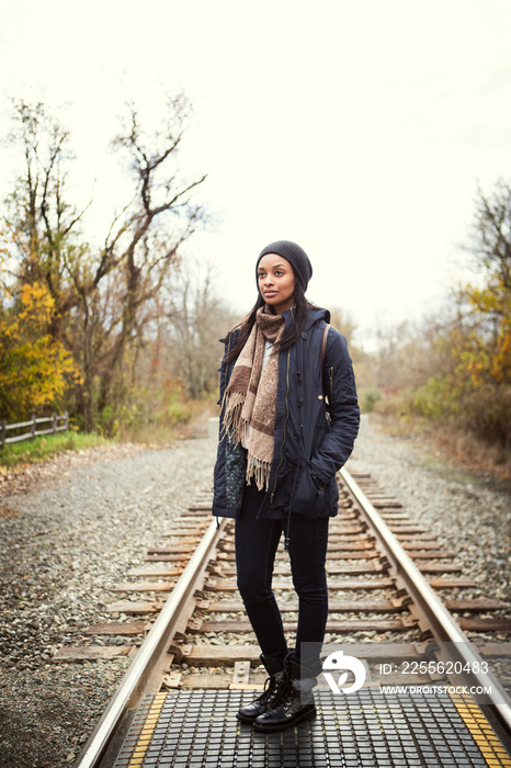 Young woman standing on railroad